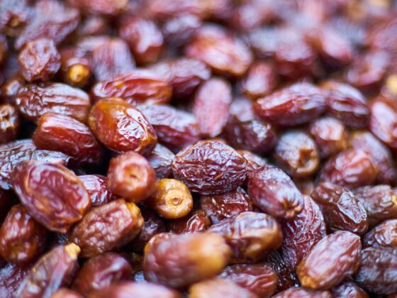 Close-up of glossy dried dates piled together with wrinkled skins.