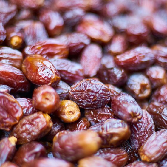 Close-up of glossy dried dates piled together with wrinkled skins.