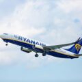 Ryanair airplane taking off, blue and yellow livery against a cloudy sky