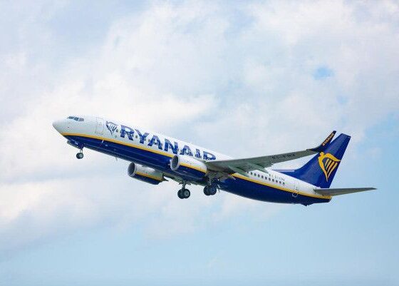 Ryanair airplane taking off, blue and yellow livery against a cloudy sky