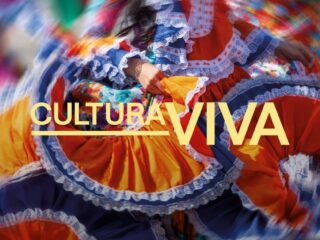 Vibrant traditional dancers in multi‑colored dresses with lace trim, motion blurred, overlaid with the text CULTURAL VIVA.