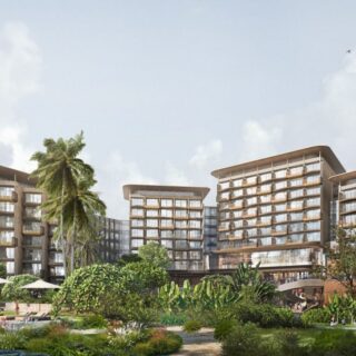 A modern tropical hotel complex with curved glass buildings, a central pool, and lush landscaping including palm trees and greenery.