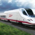 White Talgo high-speed train with red stripe racing along a rural railway on a sunny day.
