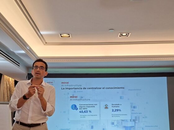 Hombre de negocios con camisa blanca da una presentación frente a una pantalla con diapositivas en español.