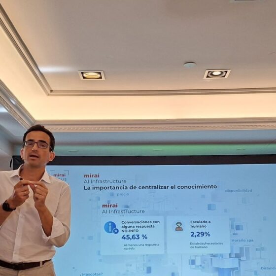 Hombre de negocios con camisa blanca da una presentación frente a una pantalla con diapositivas en español.