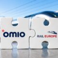 Two interlocking puzzle pieces displaying the Omio and Rail Europe logos, with a high-speed train in the background.