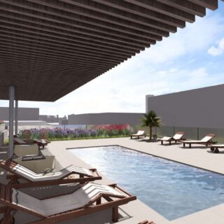 Rooftop pool deck with wooden lounge chairs, a shaded pergola, and planters against a city skyline backdrop.