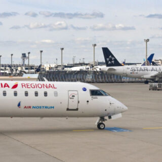 Airline planes on a tarmac at an airport, Iberia Regional and Air Nostrum in the foreground with other jets parked in the background.