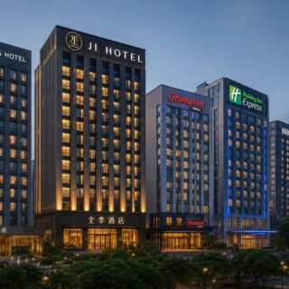 Row of tall hotel buildings at dusk with illuminated signs along the skyline.