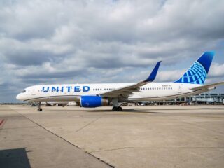 United Airlines plane parked on the tarmac with blue tail at an airport.
