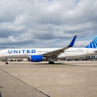 United Airlines plane parked on the tarmac with blue tail at an airport.