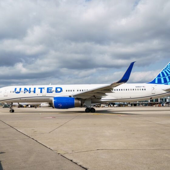 United Airlines plane parked on the tarmac with blue tail at an airport.