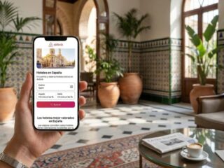 Person holding a phone displaying the Airbnb hotel search screen in a stylish hotel lobby is visible in the image.