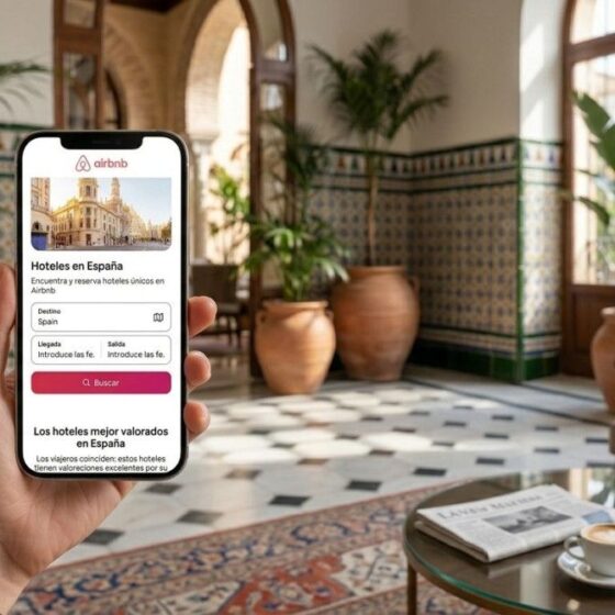 Person holding a phone displaying the Airbnb hotel search screen in a stylish hotel lobby is visible in the image.